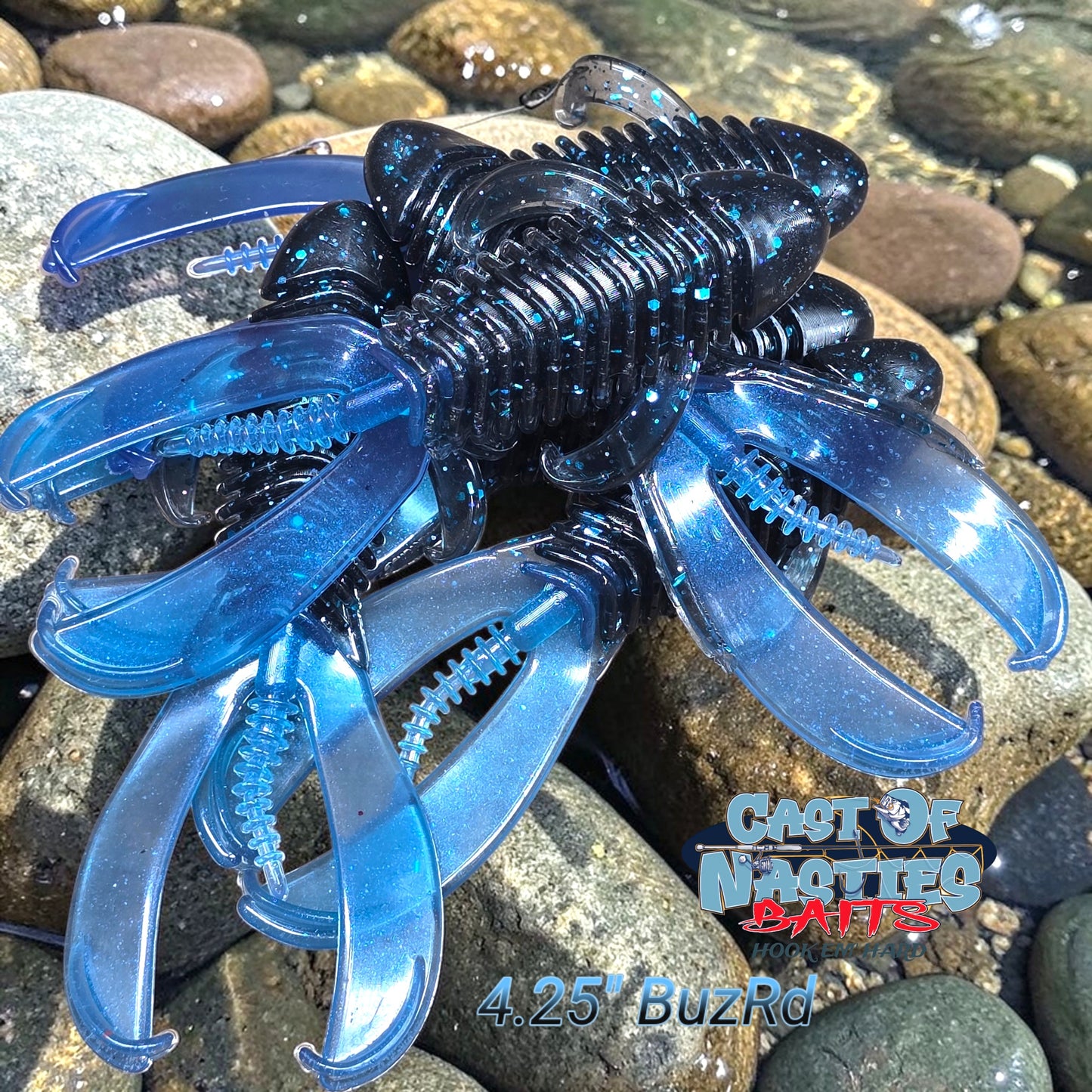 Blue and black creature-shaped fishing lure on a rocky surface